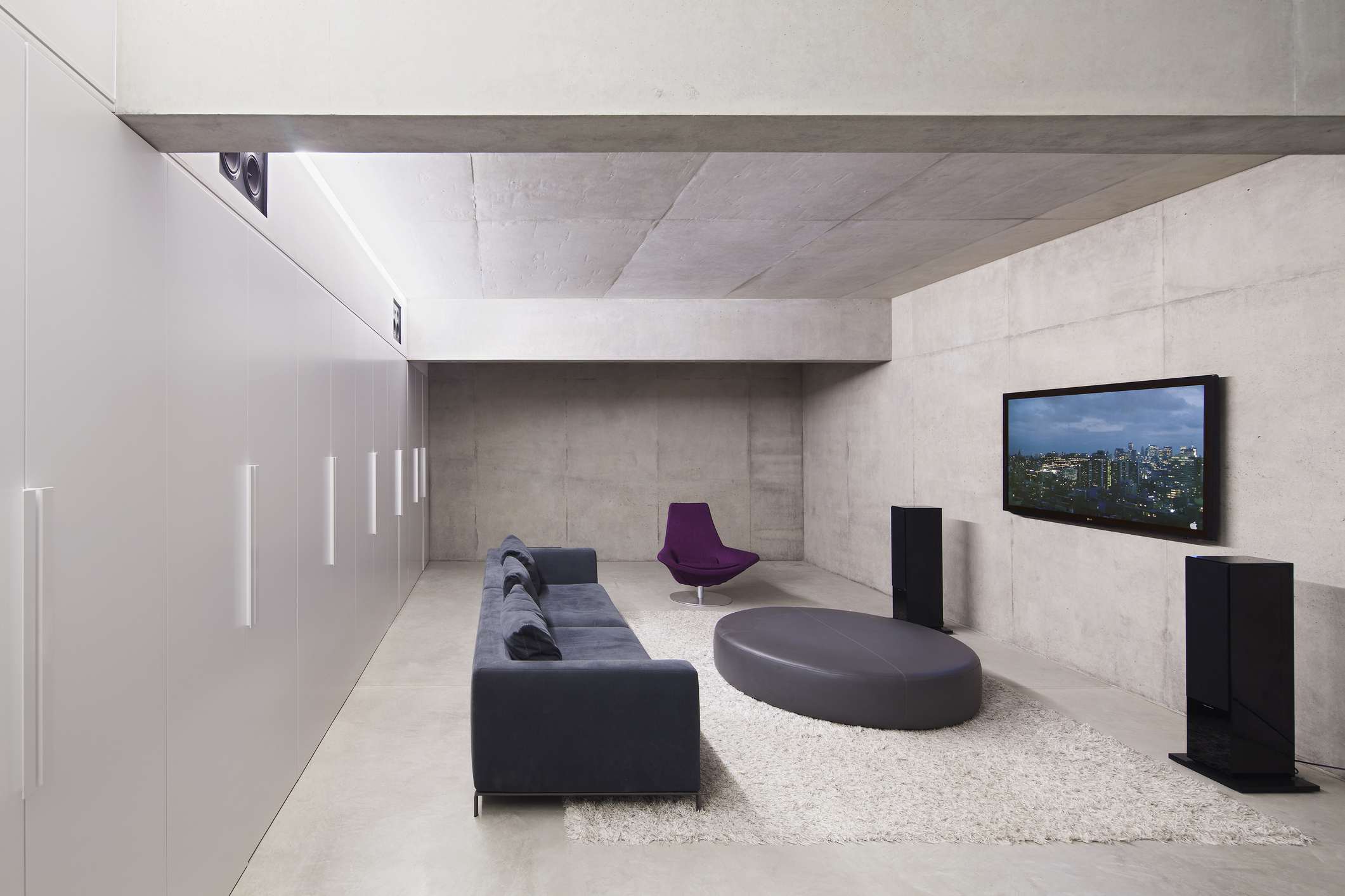 Moderne woonkamer met tv aan de muur, stereoluidsprekers en een bank