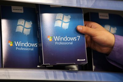 Hand met Windows 7-software in een doos in een winkeldisplay