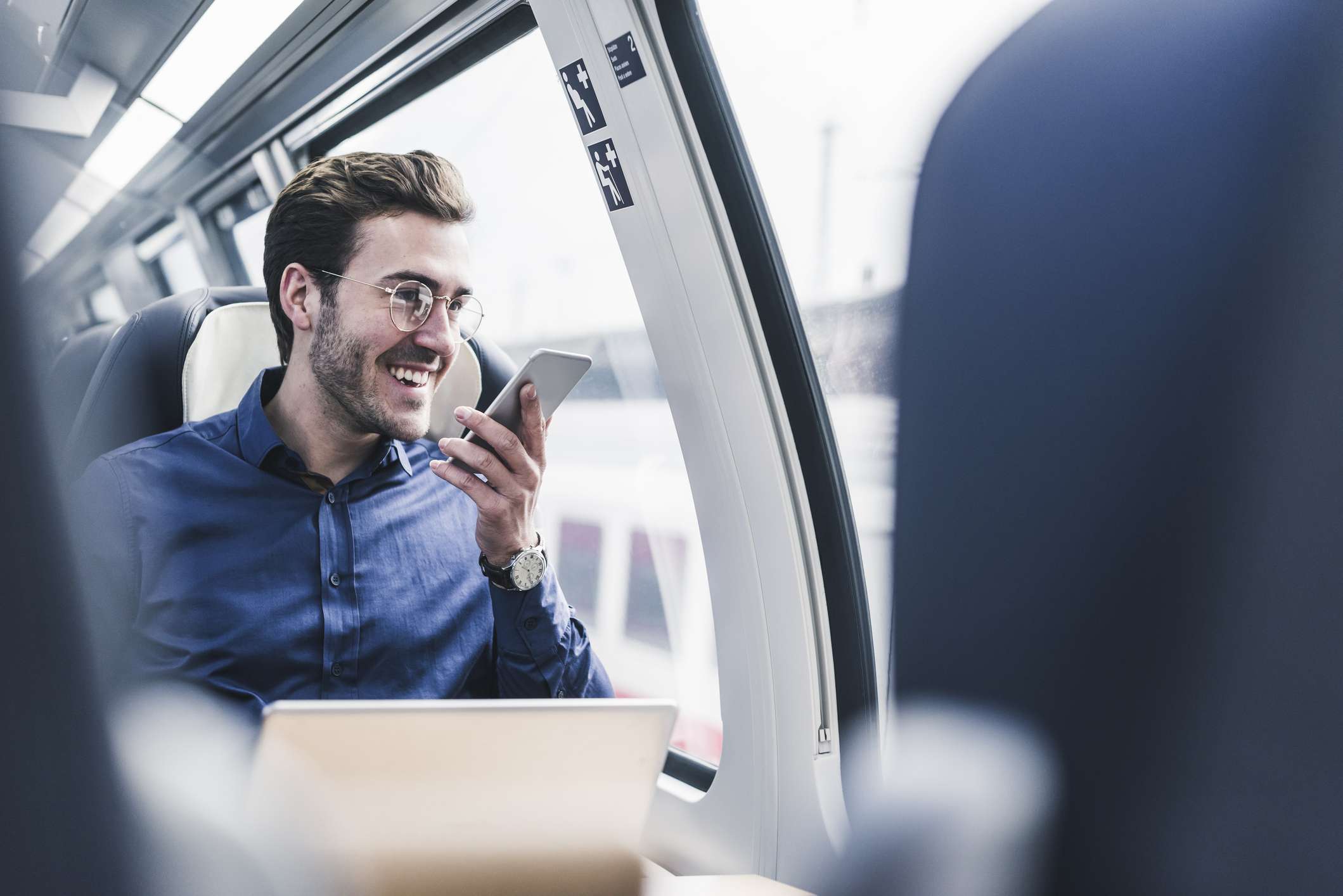 Gelukkig zakenman in een trein praten in zijn smartphone talking