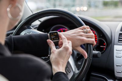 Vrouw controleert haar Apple Watch in een auto
