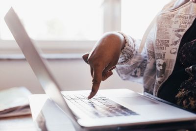 Een vinger die boven een Mac-toetsenbord zweeft, klaar om op een toets te drukken