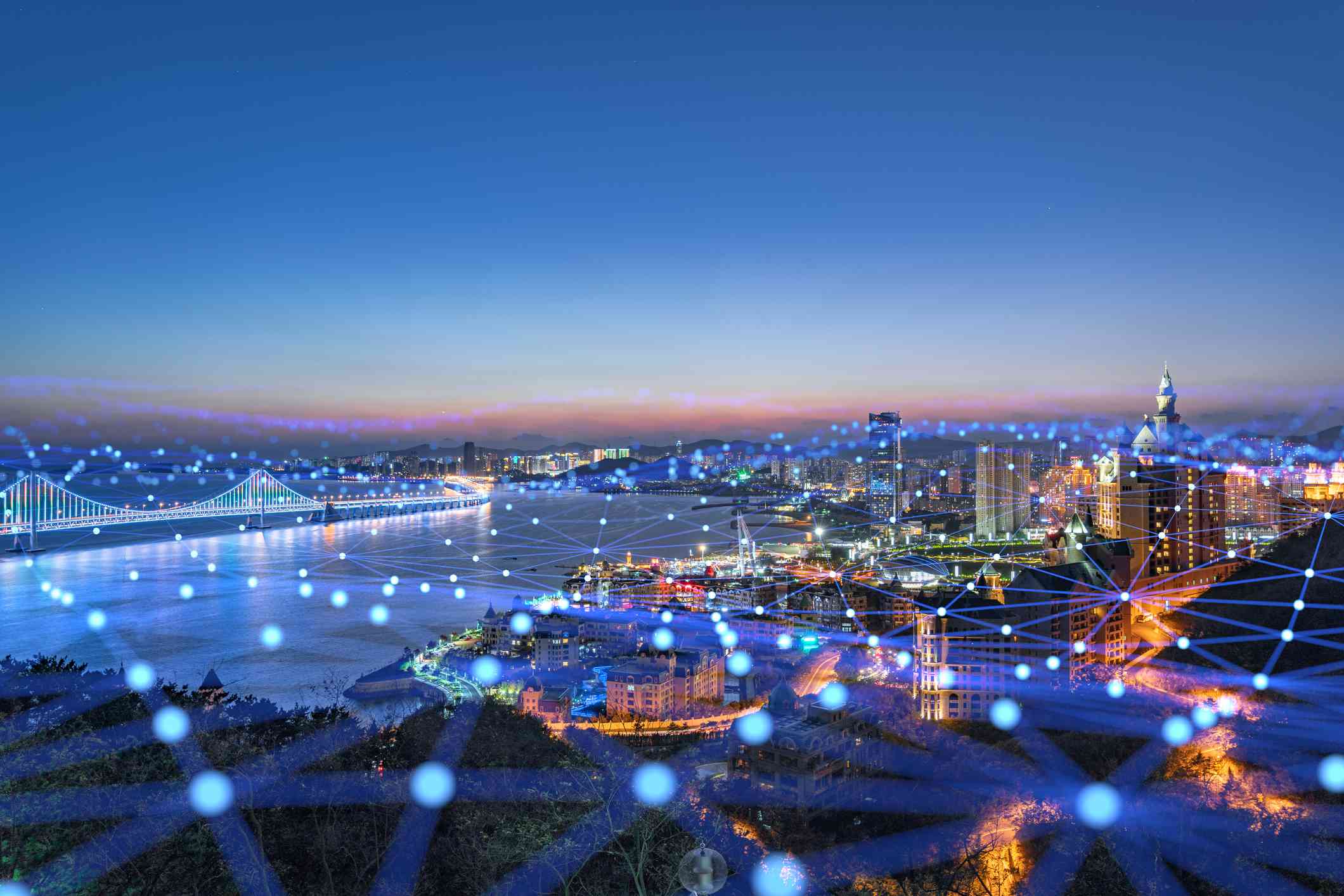 Een stad bedekt met een web van transparante blauwe lichten en lijnen die connectiviteit vertegenwoordigen