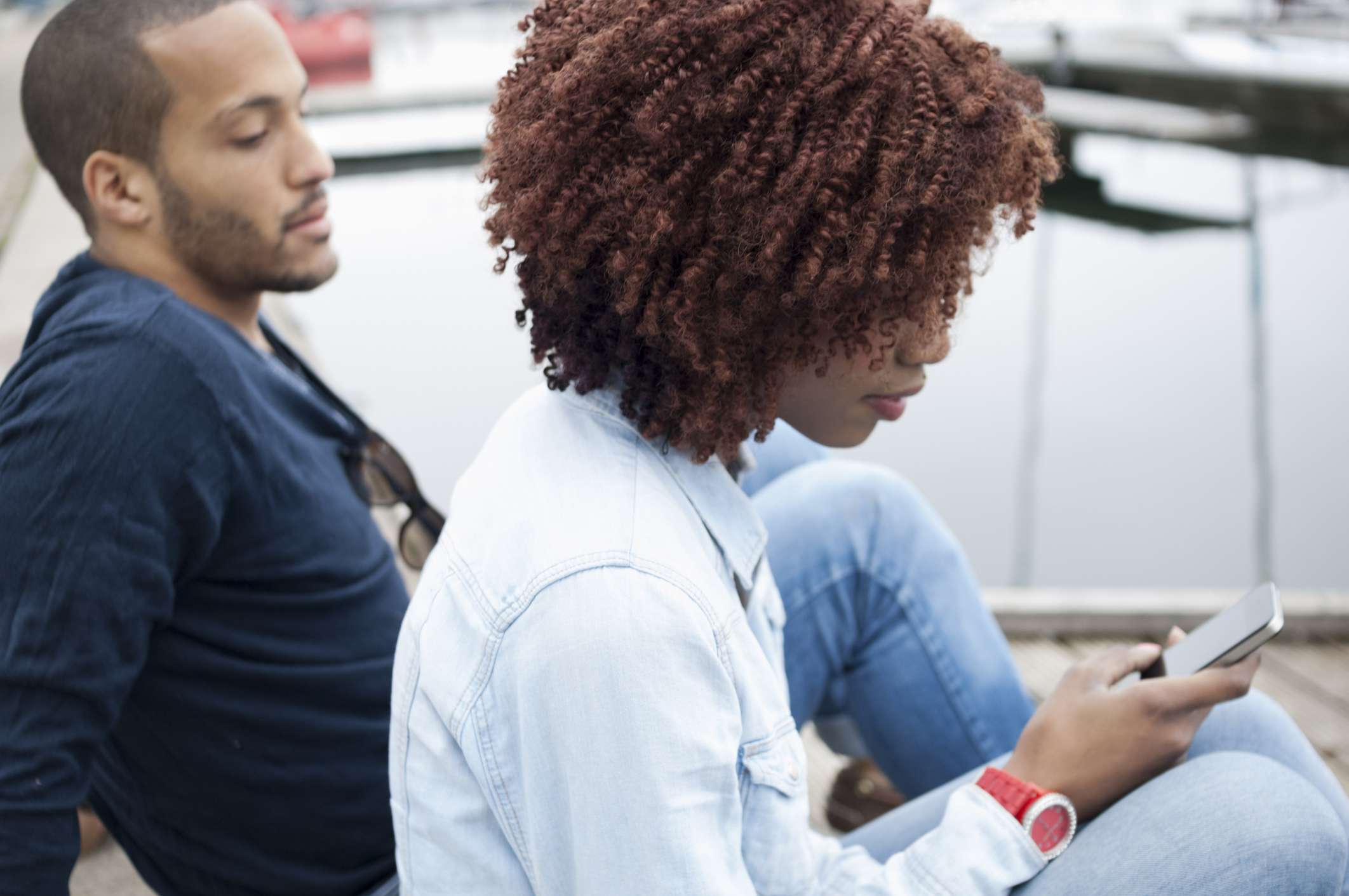 vrouw die mobiele telefoon gebruikt, man kijkt