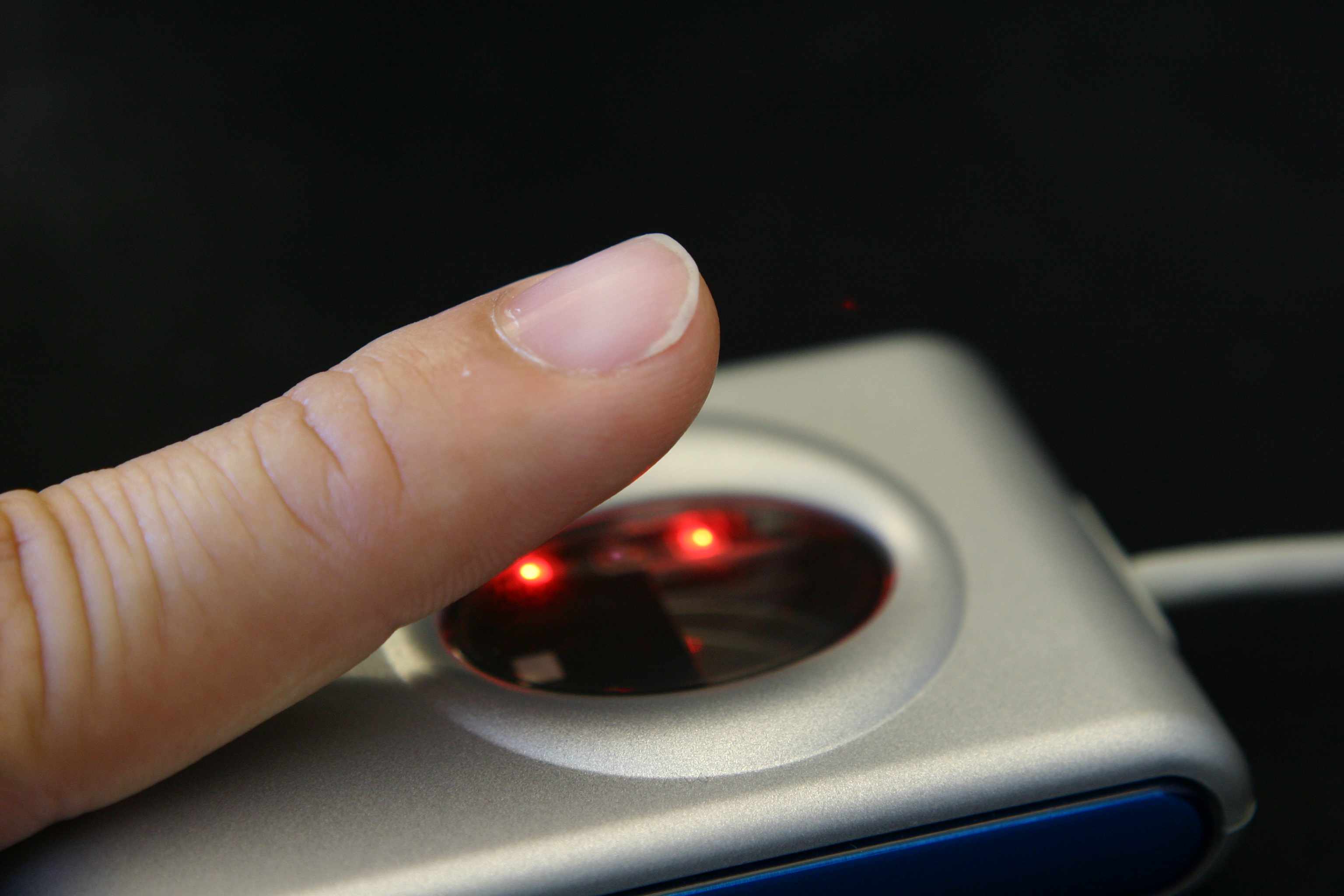 Close-up van een vinger op een vingerafdrukscanner.