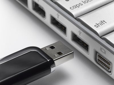 USB-flashstation op het punt om verbinding te maken met laptop, close-up.