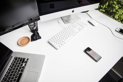 Een Macbook pro op een bureau met een monitor en toetsenbord, 
