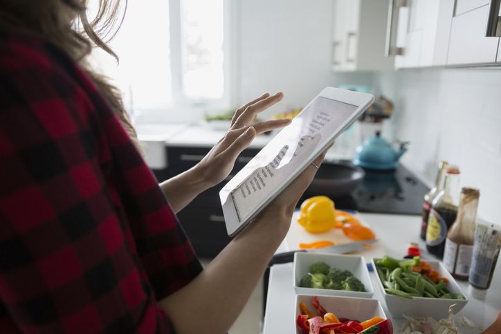 Vrouw met digitale tablet koken in de keuken