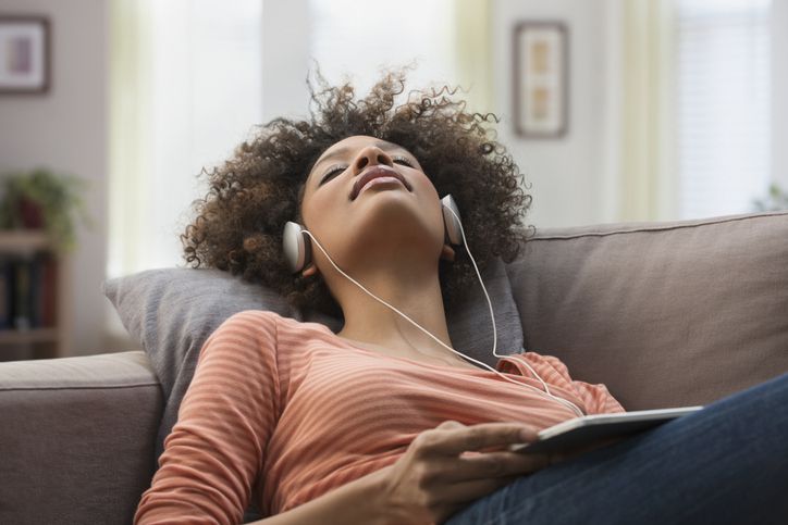 Vrouw die een koptelefoon draagt ​​en naar muziek luistert op een tablet