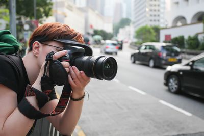 Vrouw die een DSLR fotografeert in de stad