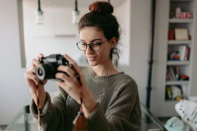 Jonge fotograaf met camera in appartement
