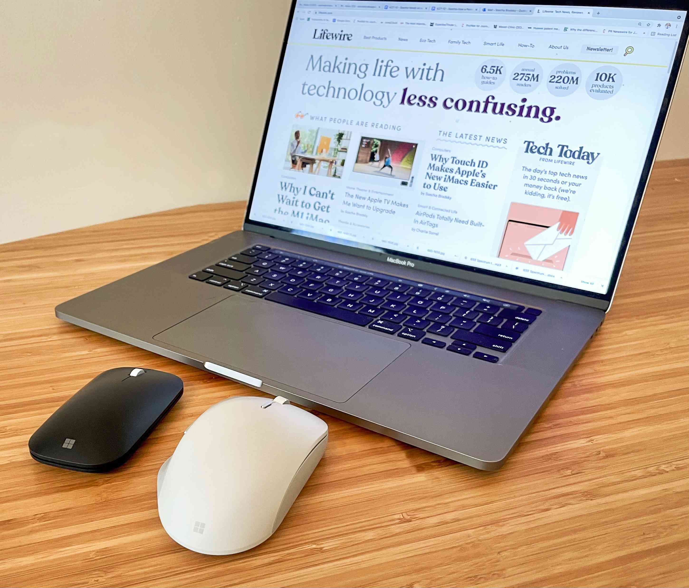 De Microsoft Surface Mouse en Surface Mouse Mini zitten voor een MacBook Pro-computer. 