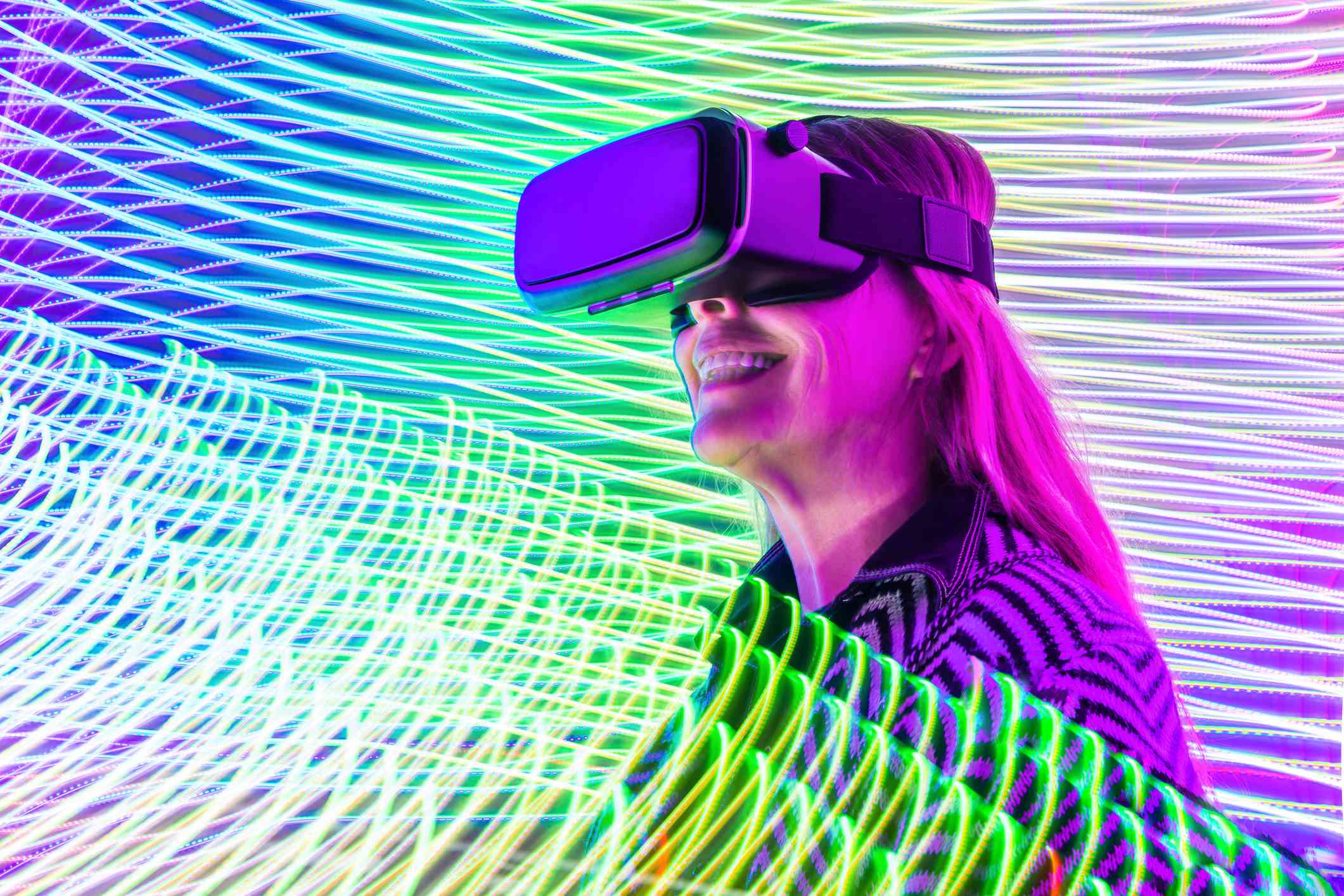 Vrouw geniet van VR terwijl ze wordt omringd door kleurrijke spiralen