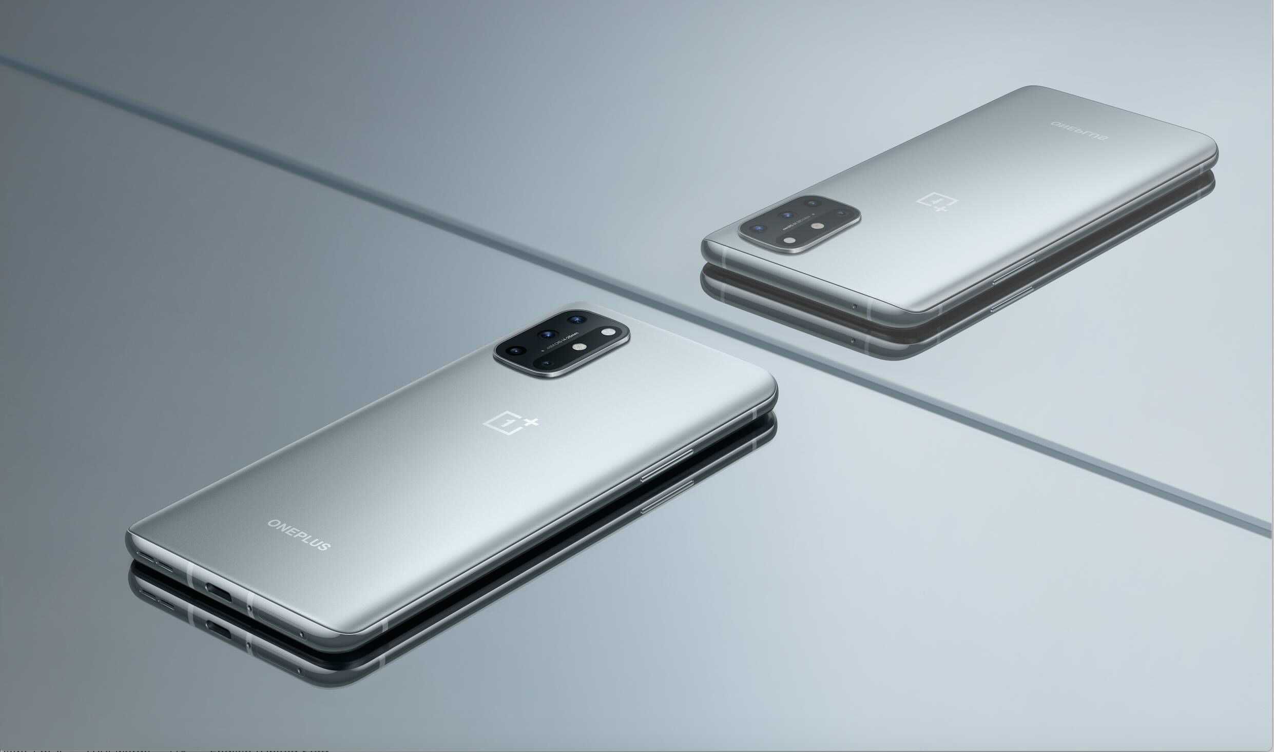 Een grijze OnePlus 8T met de voorkant naar beneden met zijn reflectie in een spiegel
