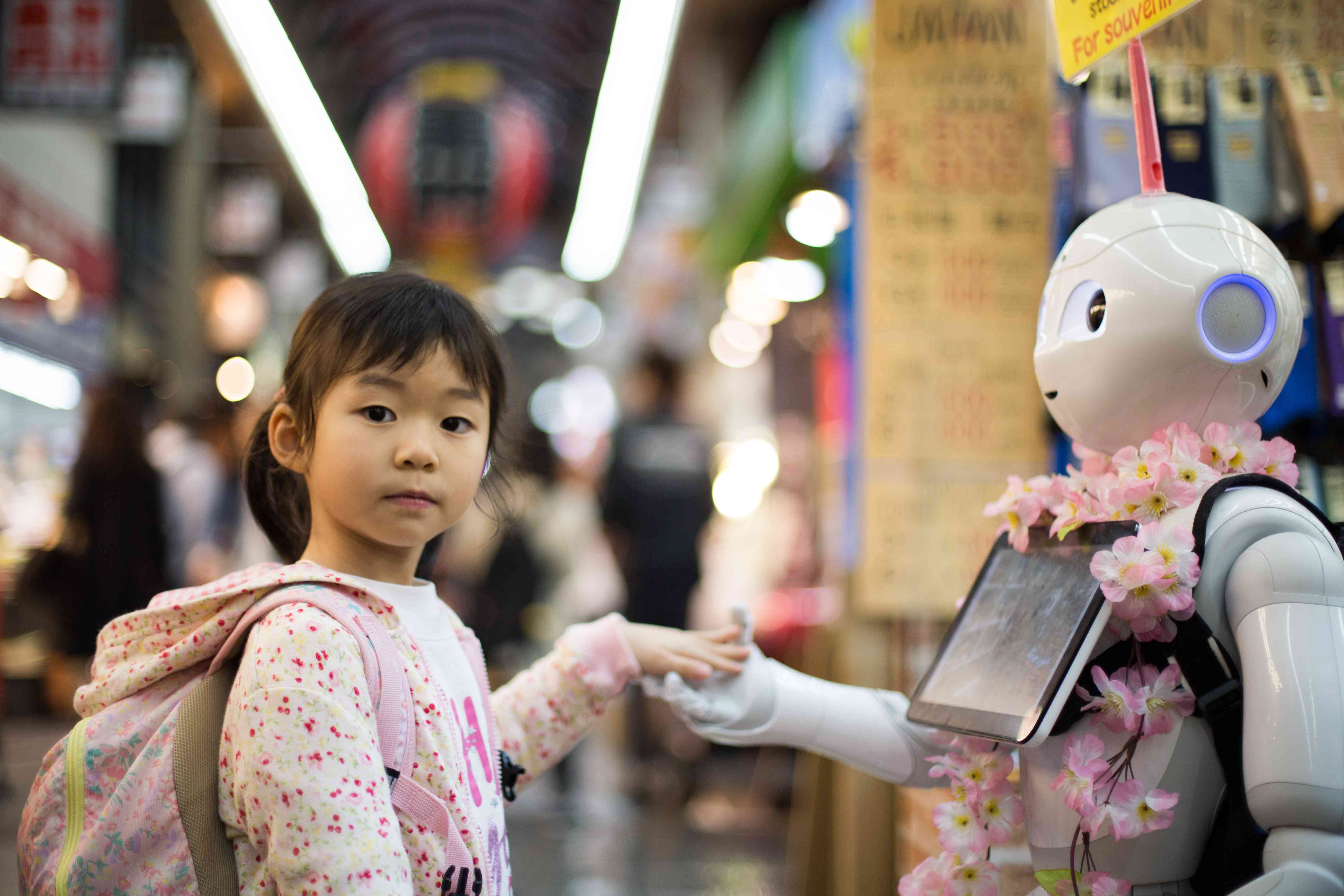 Een kind dat de hand van een robot vasthoudt op een drukke markt.