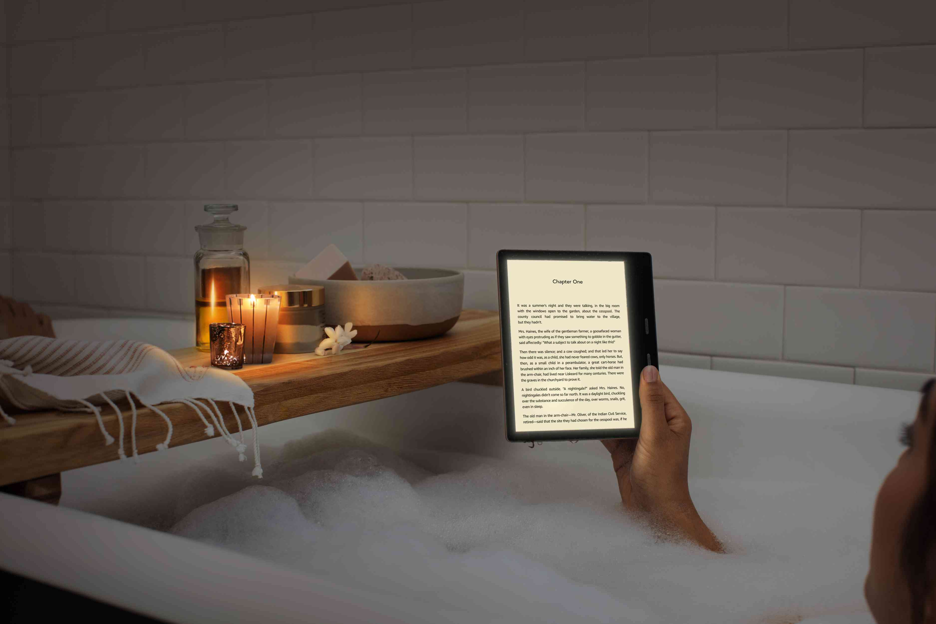 Iemand leest op een Amazon Oasis-tablet terwijl hij in een badkuip zit.