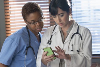 Twee artsen kijken naar een iPhone.