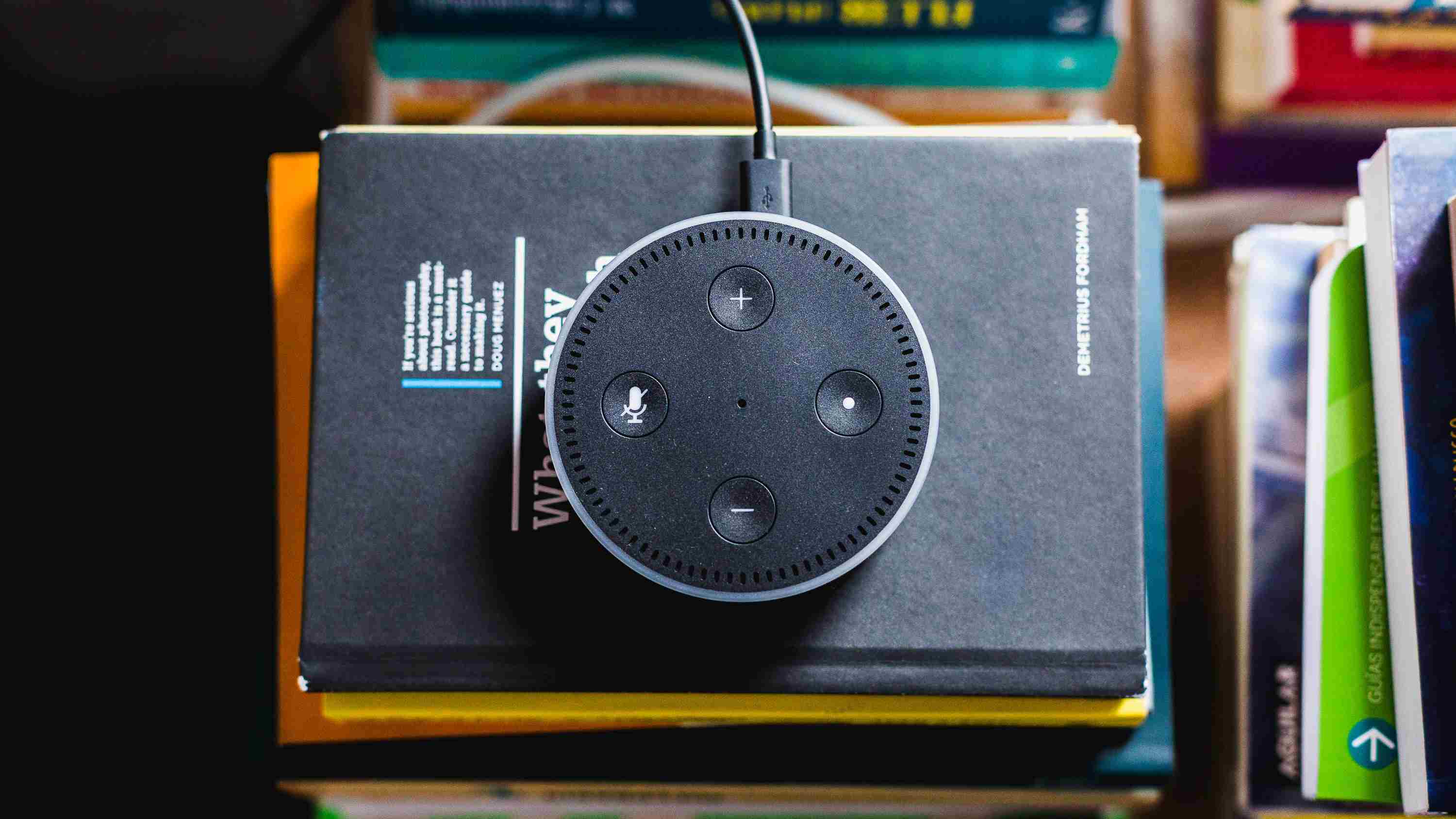Amazon Echo Dot zittend op een stapel boeken.