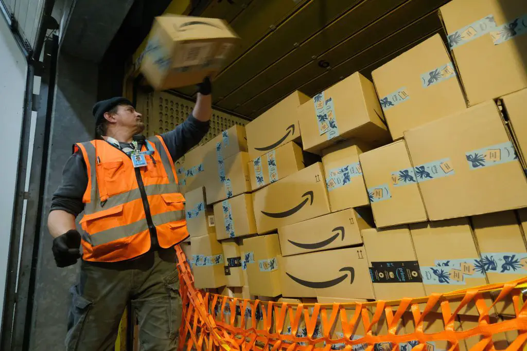 Een werknemer laadt een vrachtwagen met pakketten in een Amazon-verpakkingscentrum