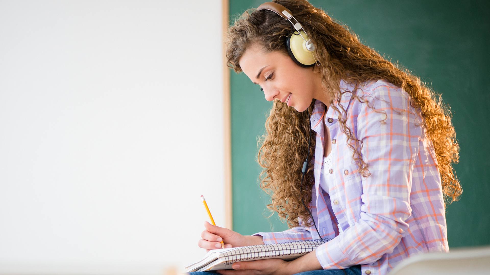 Vrouwelijke student studeert met noise-cancelling koptelefoon op