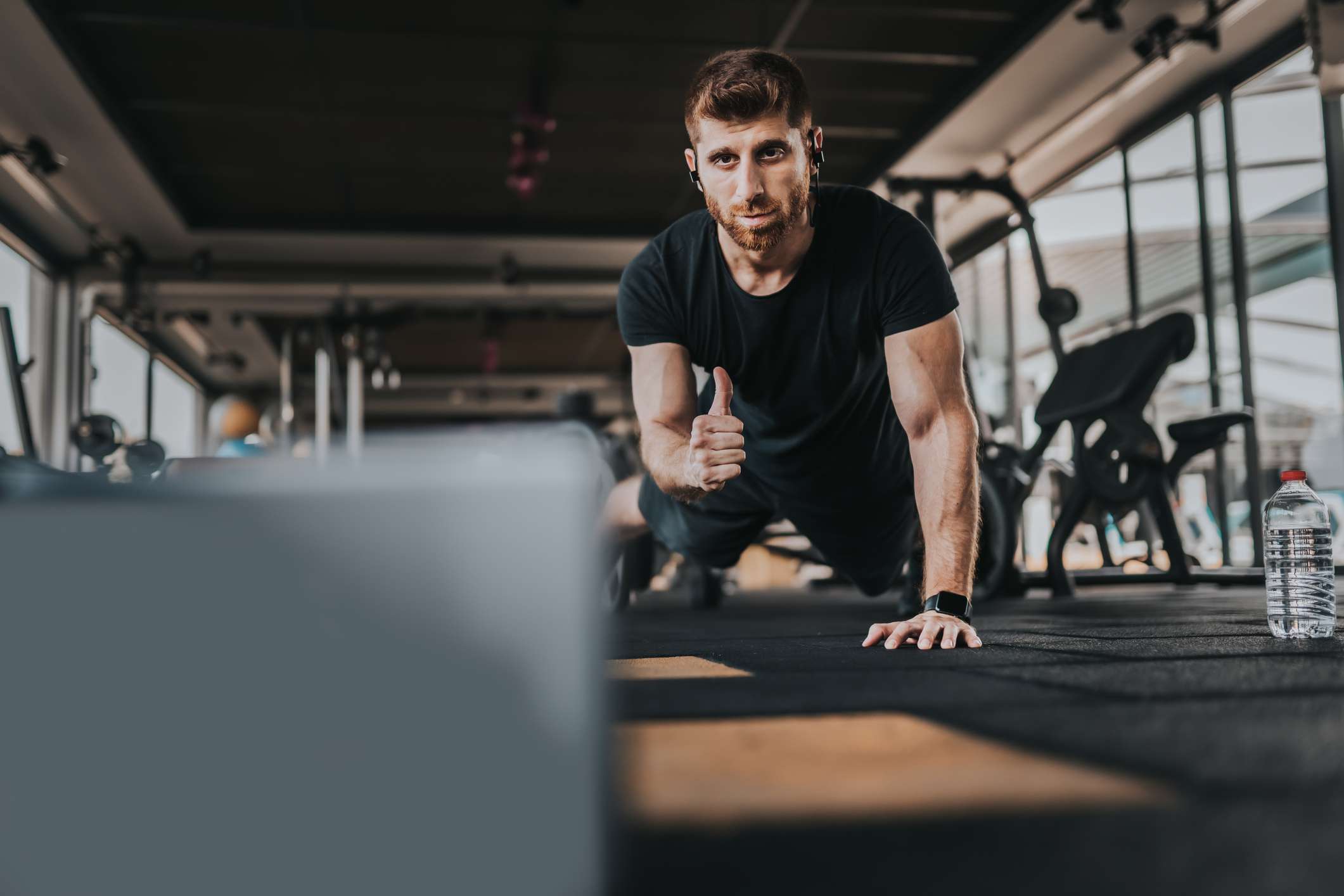 Een personal trainer die een laptop gebruikt en streamt om klanten te coachen.