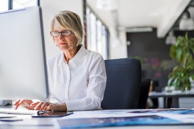 Zakenvrouw met behulp van desktopcomputer op kantoor