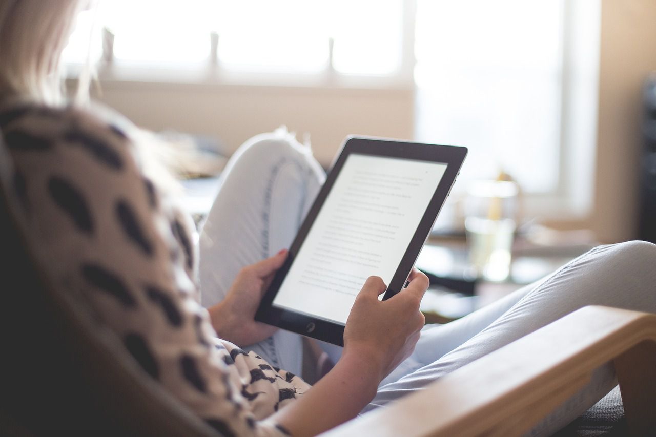 Afbeelding van een vrouw die een e-book leest op een tablet