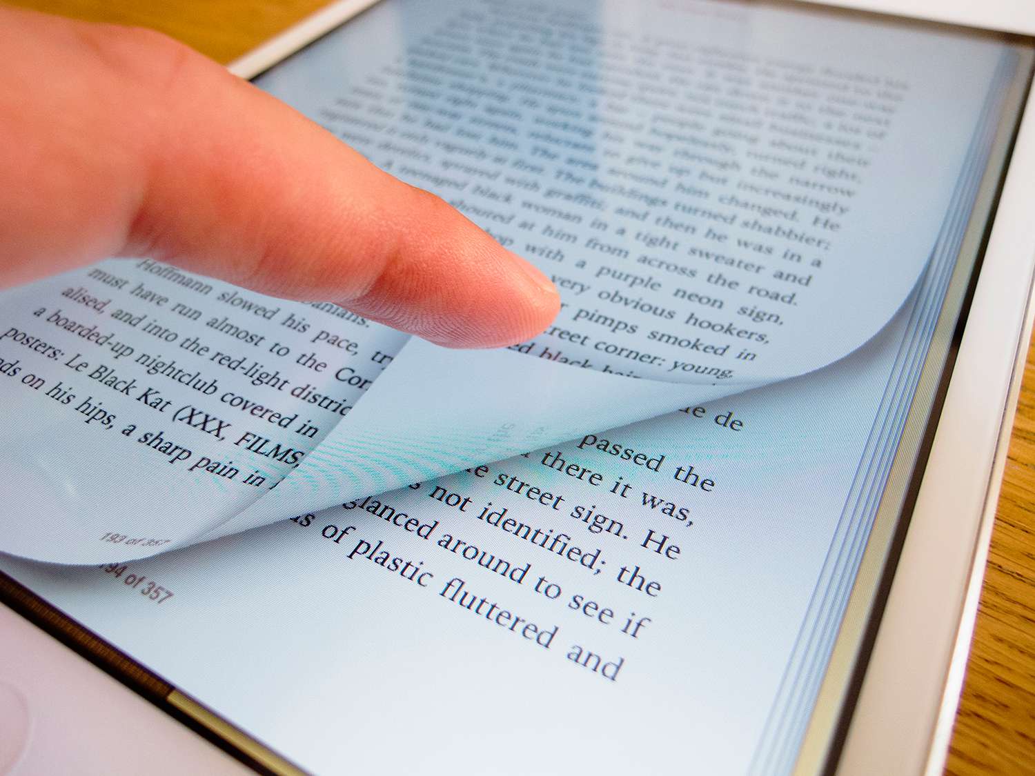 Pagina van een e-boek omslaan met een iBook-lezer op een iPad mini-tabletcomputer