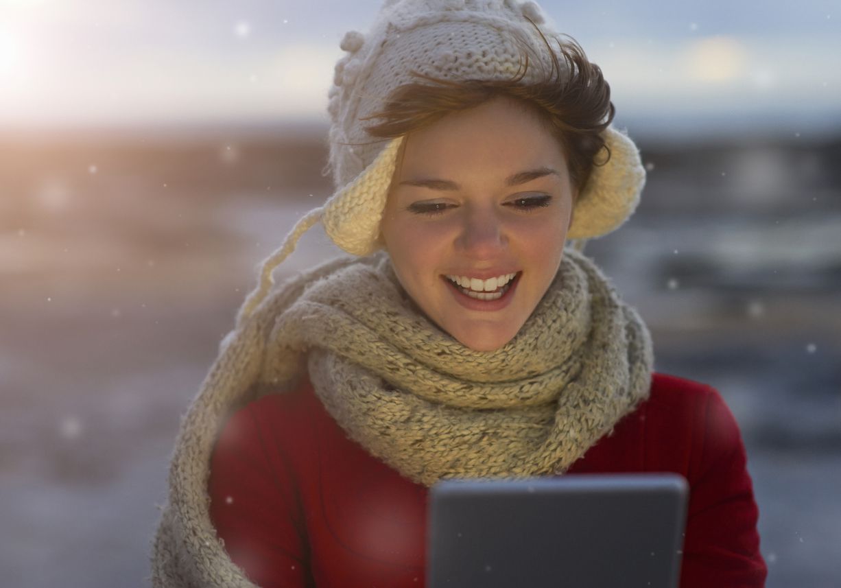 Een persoon die een tablet gebruikt terwijl het sneeuwt.