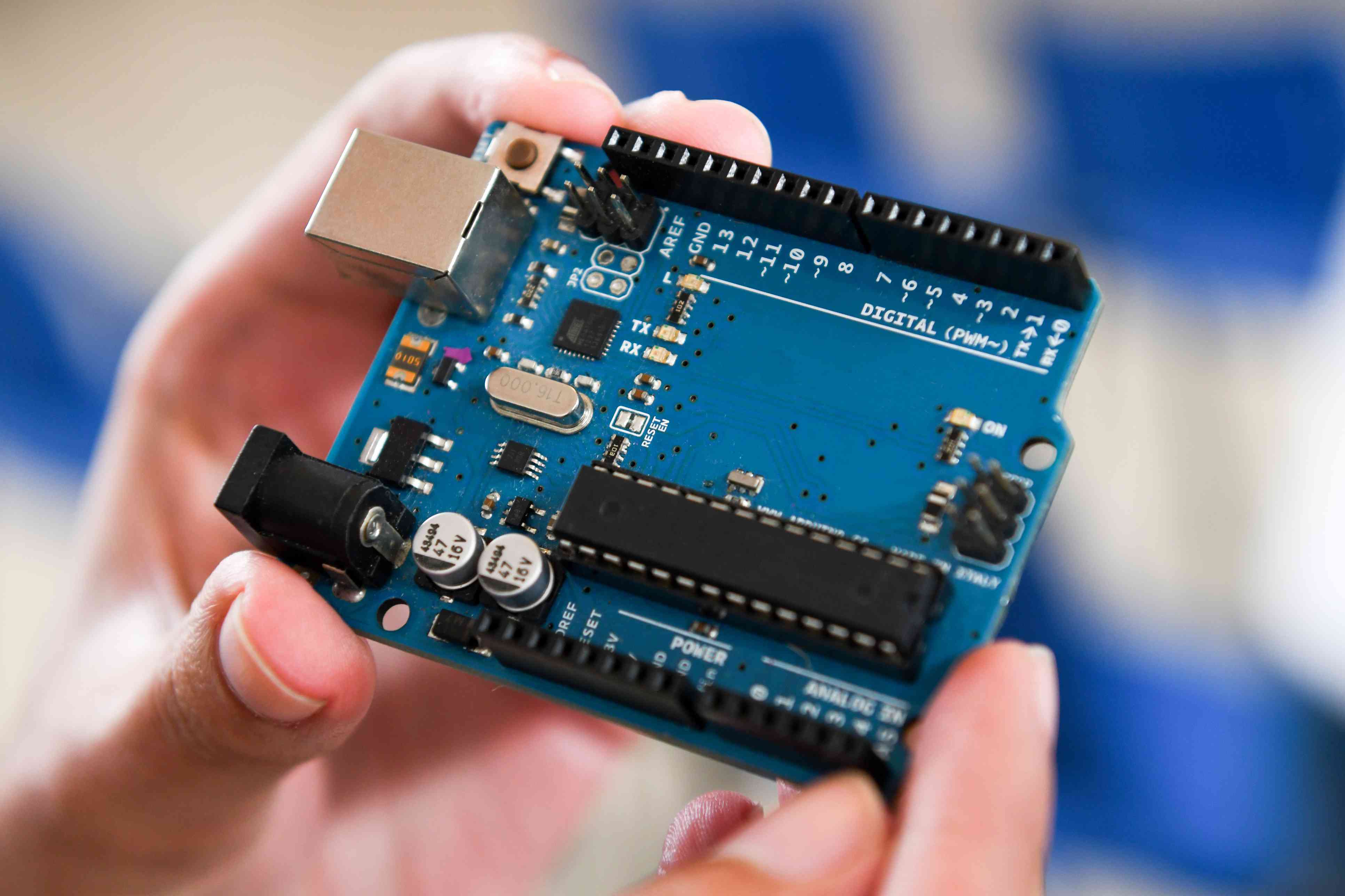 Close-up van mannelijke handen met een Arduino-microcontrollerbord