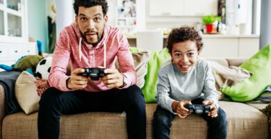 father and son concentrating while playing video games together 902906742 5b310f44eb97de00361bcc5c