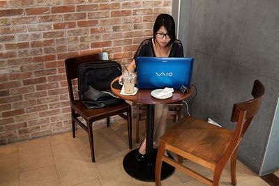 Vrouw op computer in coffeeshop