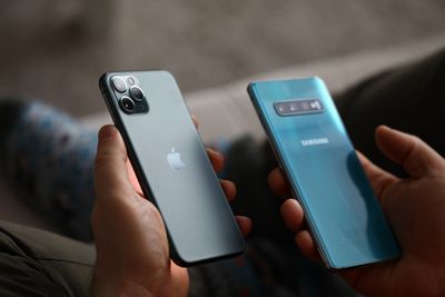 Een iPhone en Samsung-telefoon naast elkaar gehouden