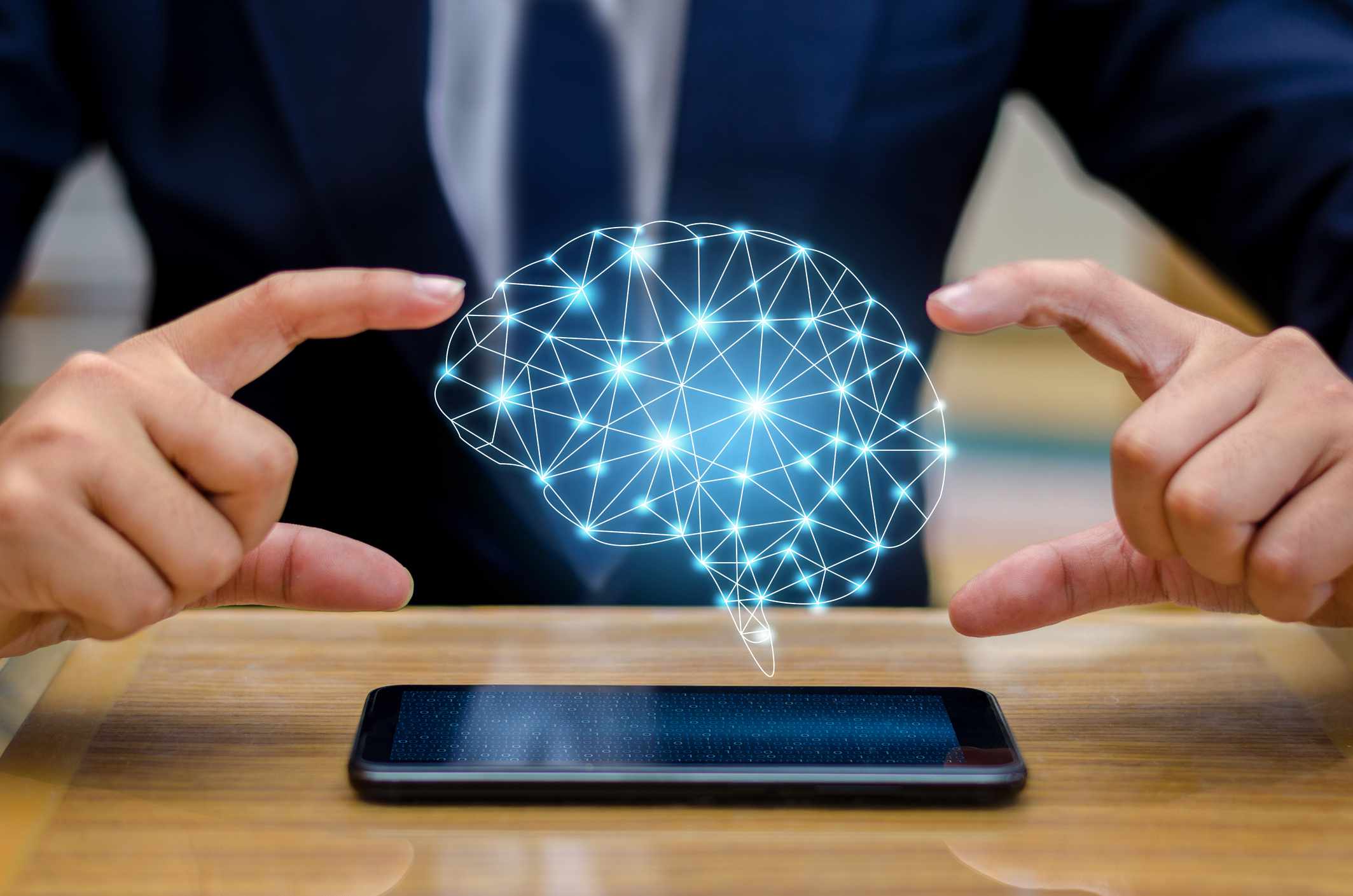 Digitaal samengesteld beeld van een zakenman die een smartphone gebruikt met een hersenpictogram eroverheen.