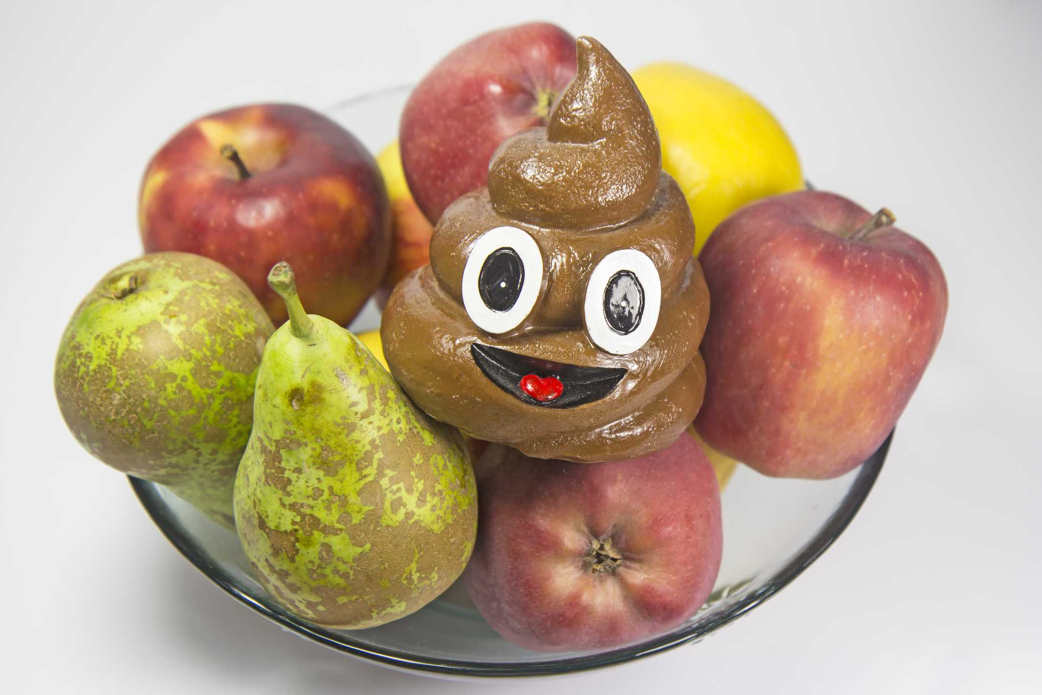 Een 3D poep-emoji in een fruitschaal
