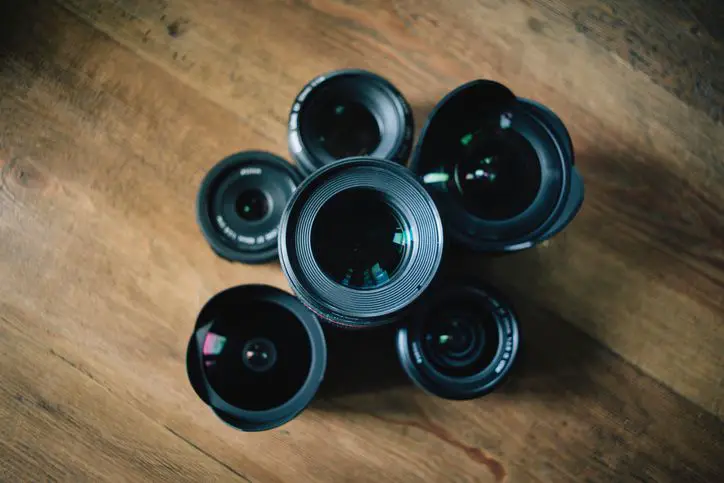 Cameralenzen gerangschikt op een houten tafel