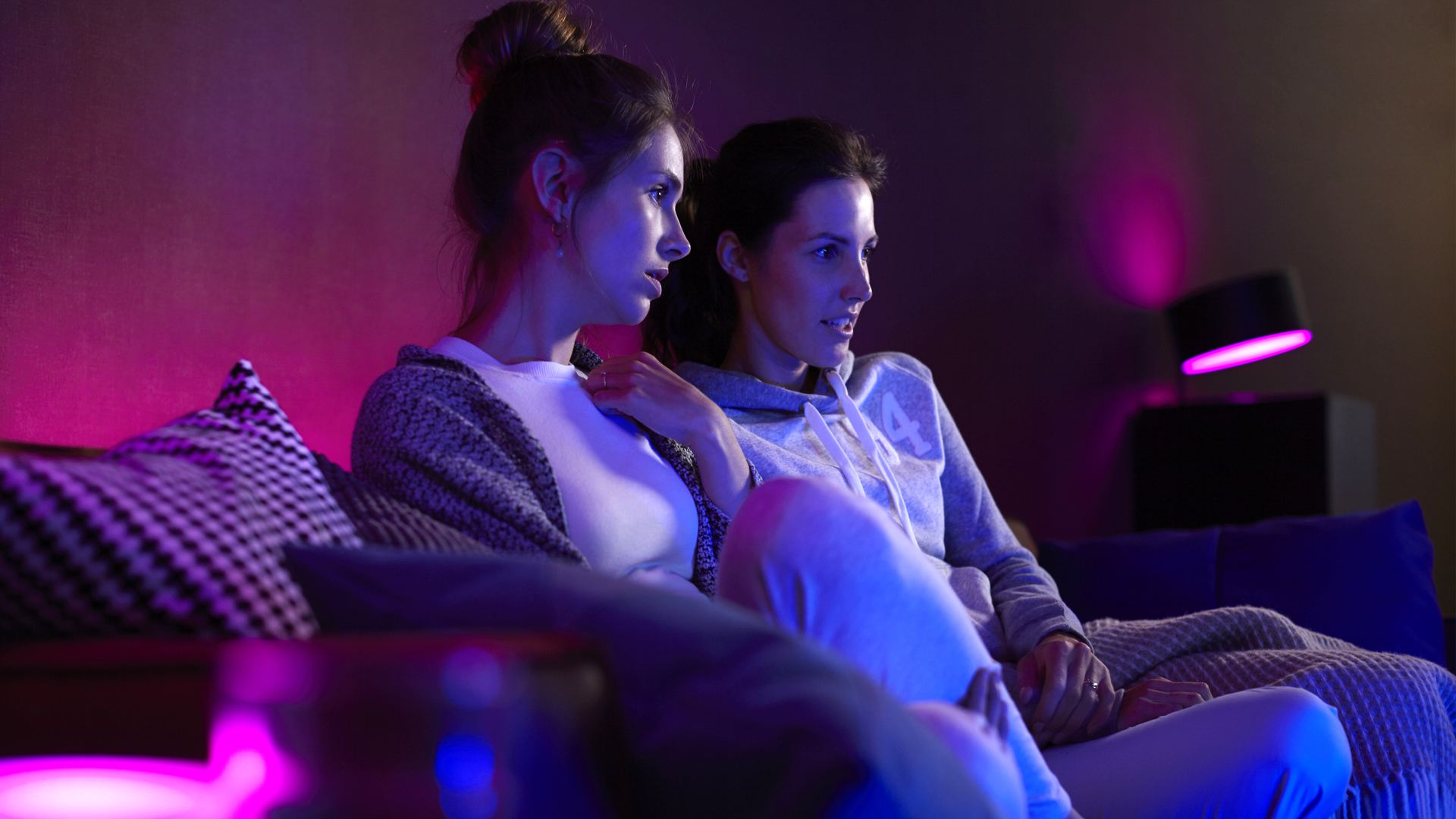 Twee vrouwen tv kijken met roze Philips Hue Lights