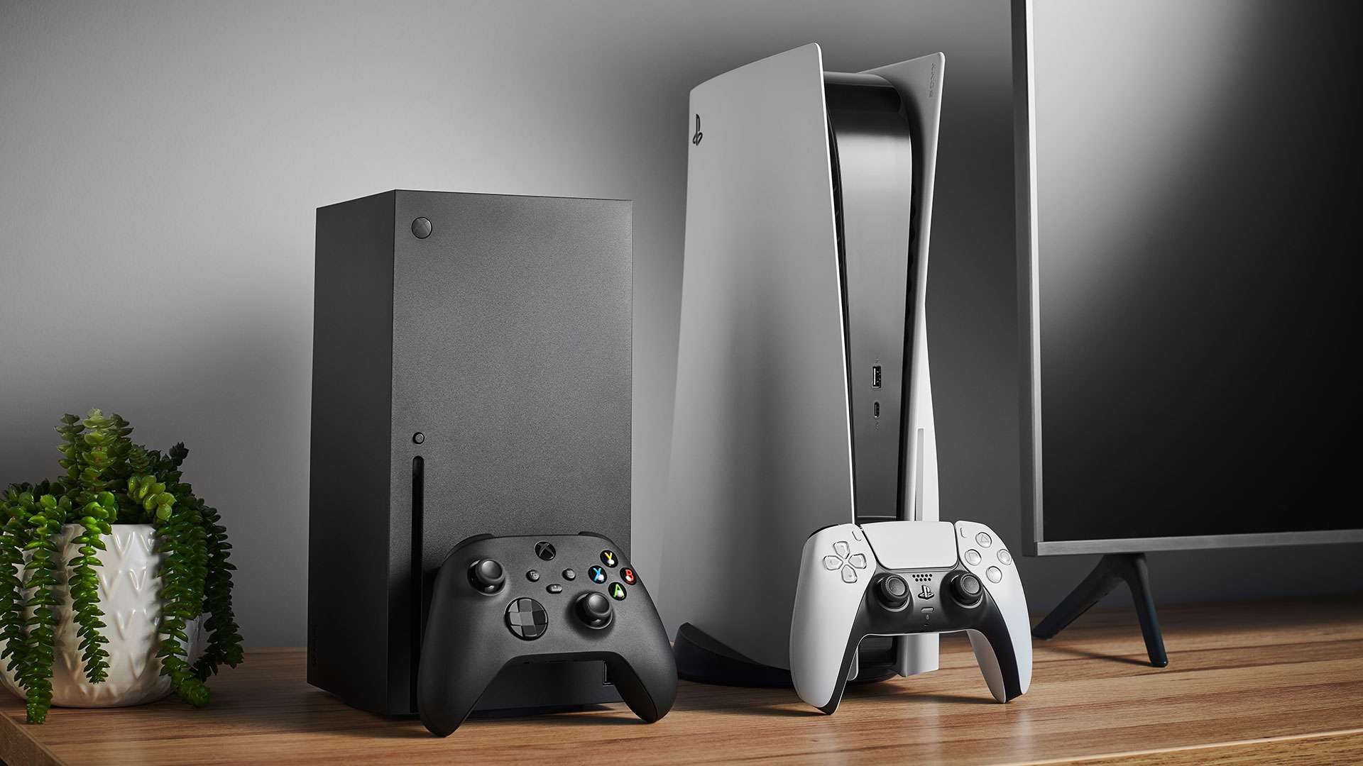 Een Xbox Series X en een PS 5 naast elkaar opgesteld op een entertainmentcentrum met een tv.