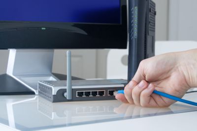 Hand die Ethernet-kabel in de achterkant van een router steekt