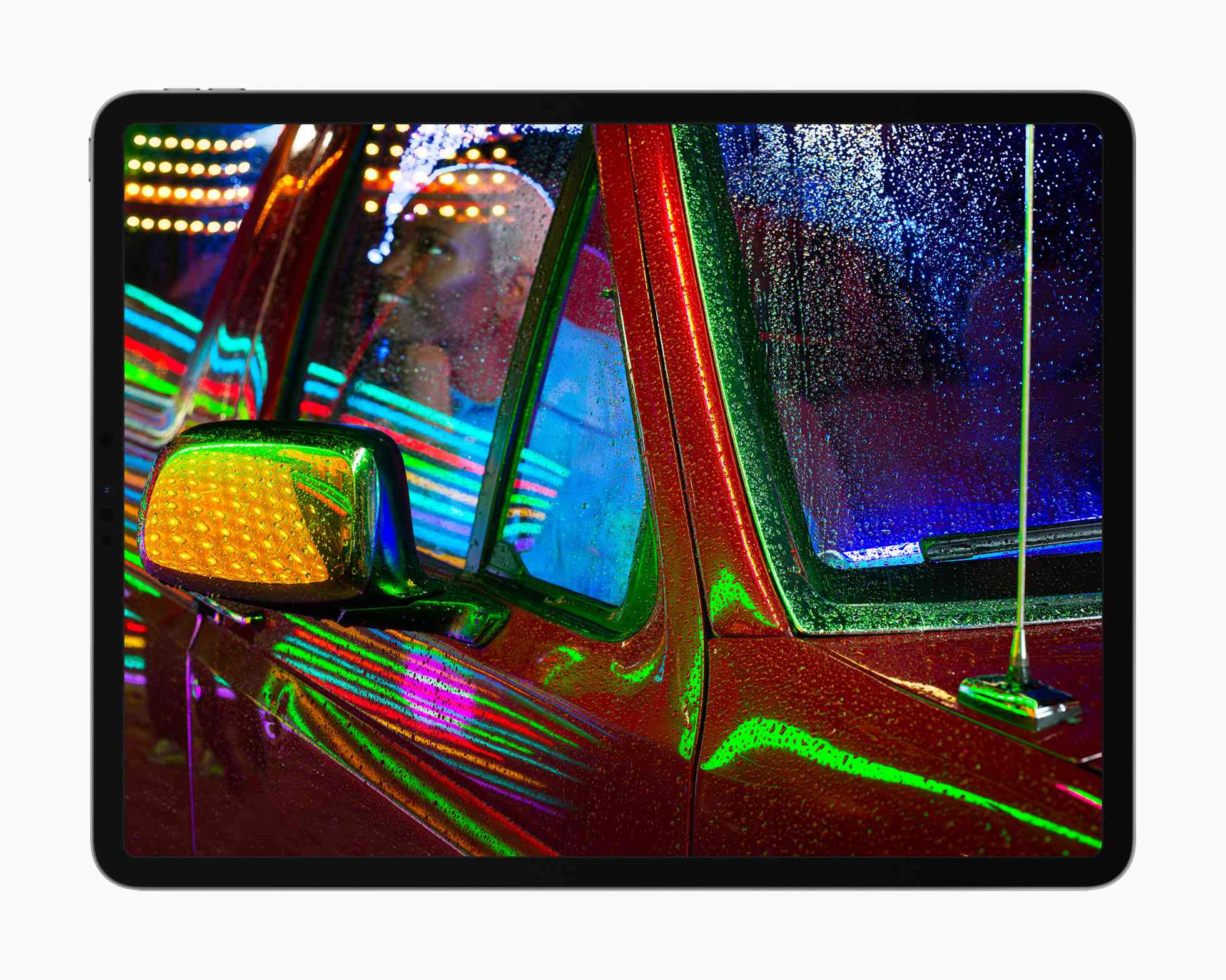 Apple iPad Pro liquidXDR-display met een foto van iemand in een pick-up truck met neonlichten die weerkaatsen op het metaal en glas.