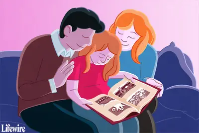 Een gezin dat dicht op een bank zit en naar een gedrukt fotoboek kijkt