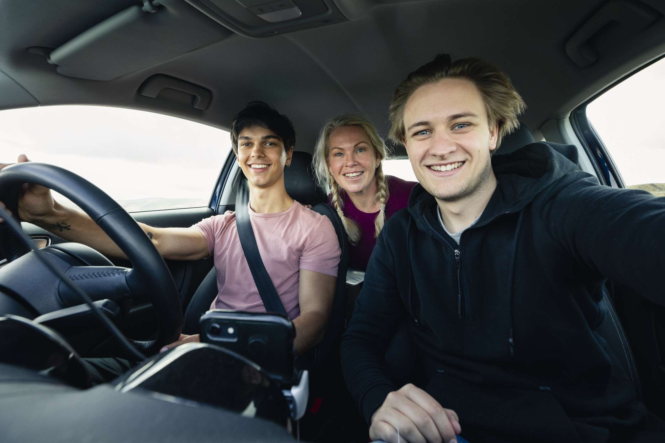 Drie jonge mensen in een auto. 