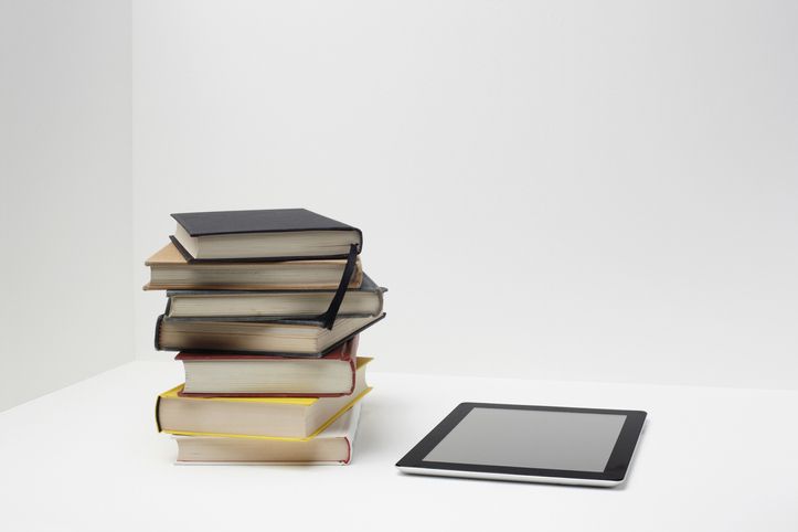 Stapel boeken met digitale tablet