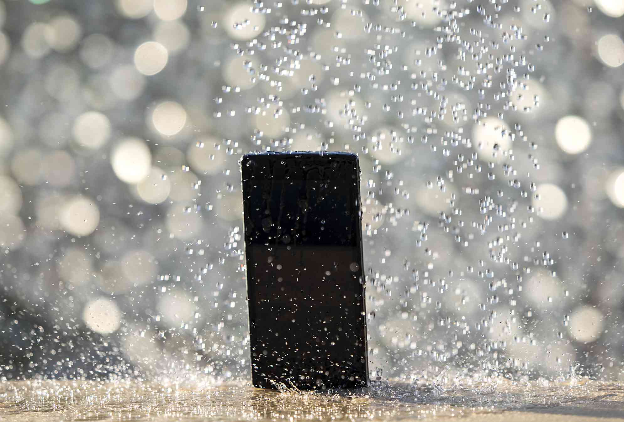 iPhone wordt doorweekt door een stortvloed van waterdruppels