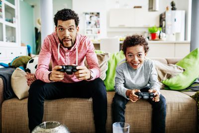 Vader en zoon concentreren zich terwijl ze samen videogames spelen