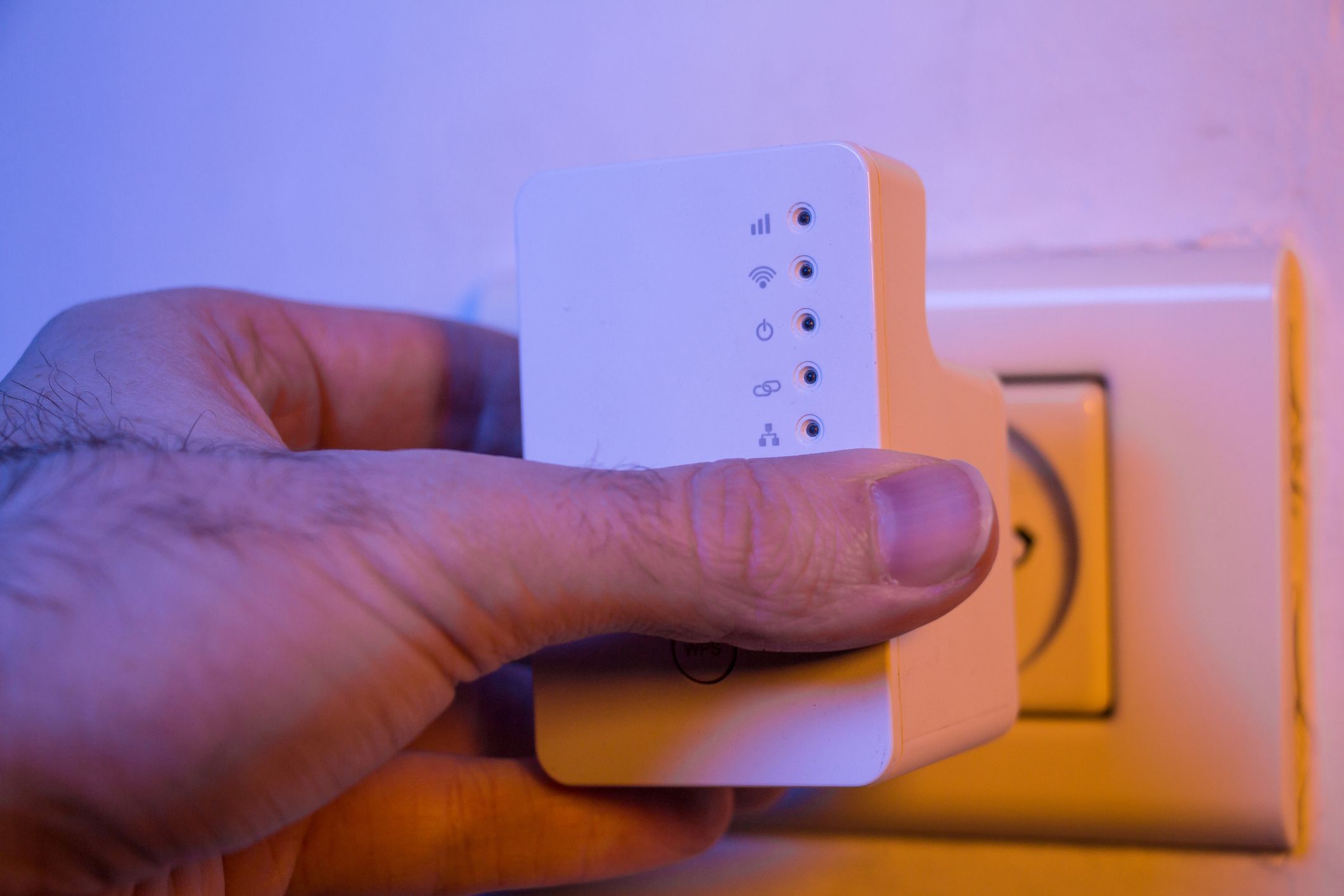 Hand een Wi-Fi-extender (repeater) in het stopcontact aan de muur steken