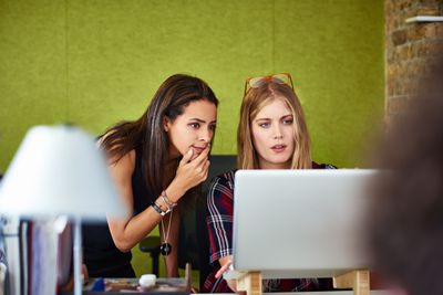 Teamgenoten die op kantoor op de computer werken terwijl ze de beveiligingsinstellingen van hun netwerk bijwerken