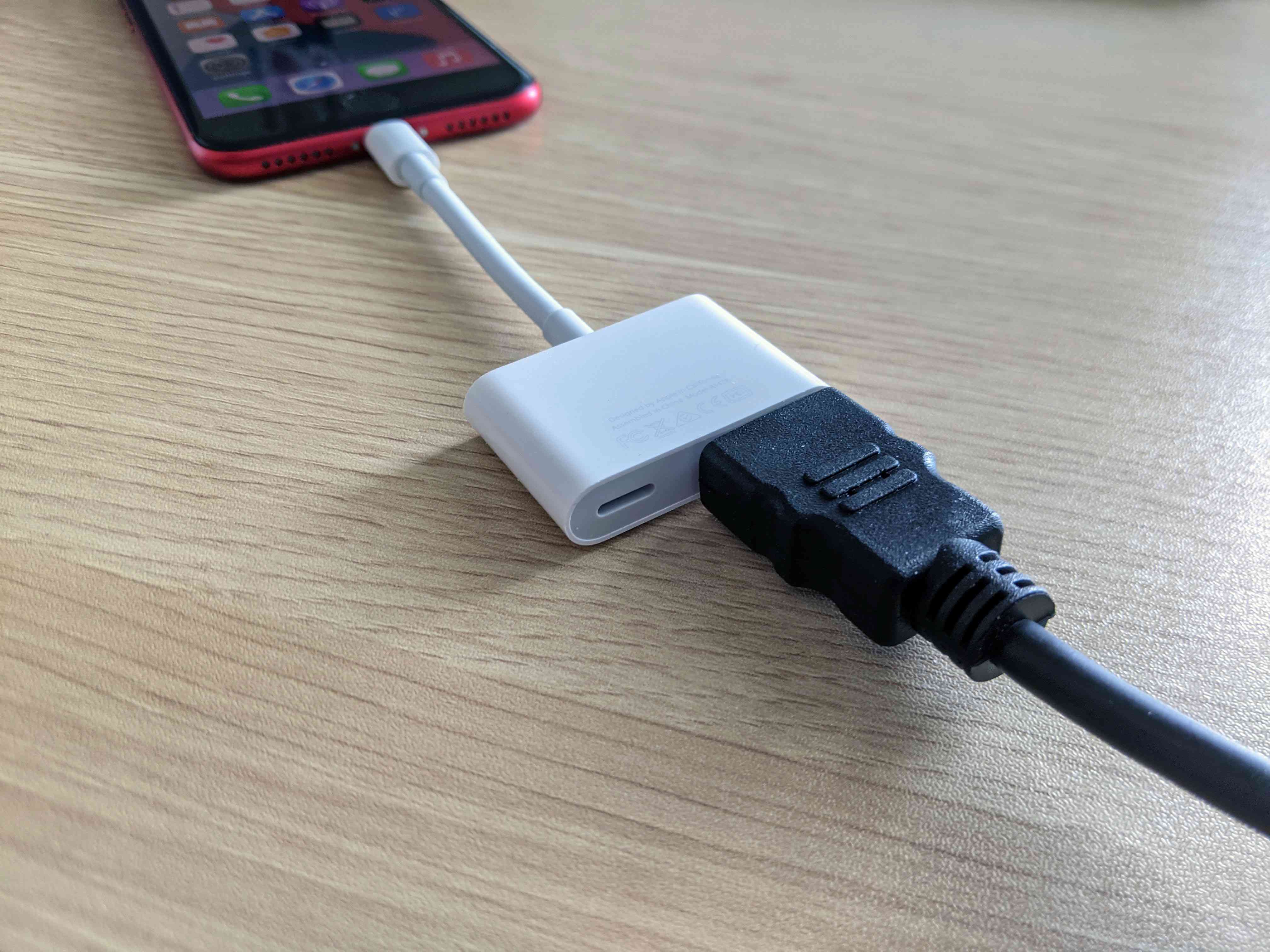 Een HDMI-kabel aangesloten op een iPhone met een adapter.