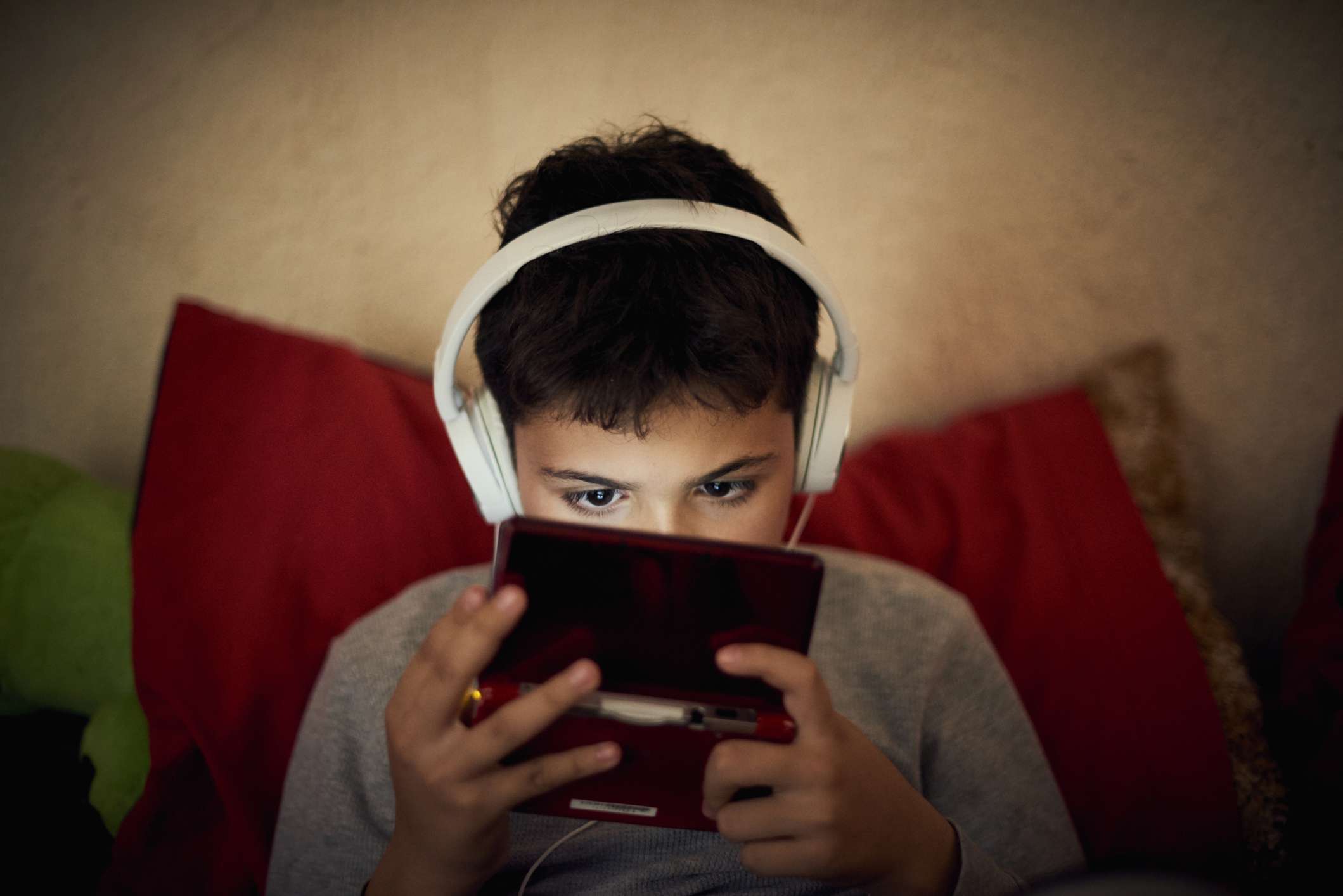 Een kind dat op een handheld-spelsysteem speelt. 