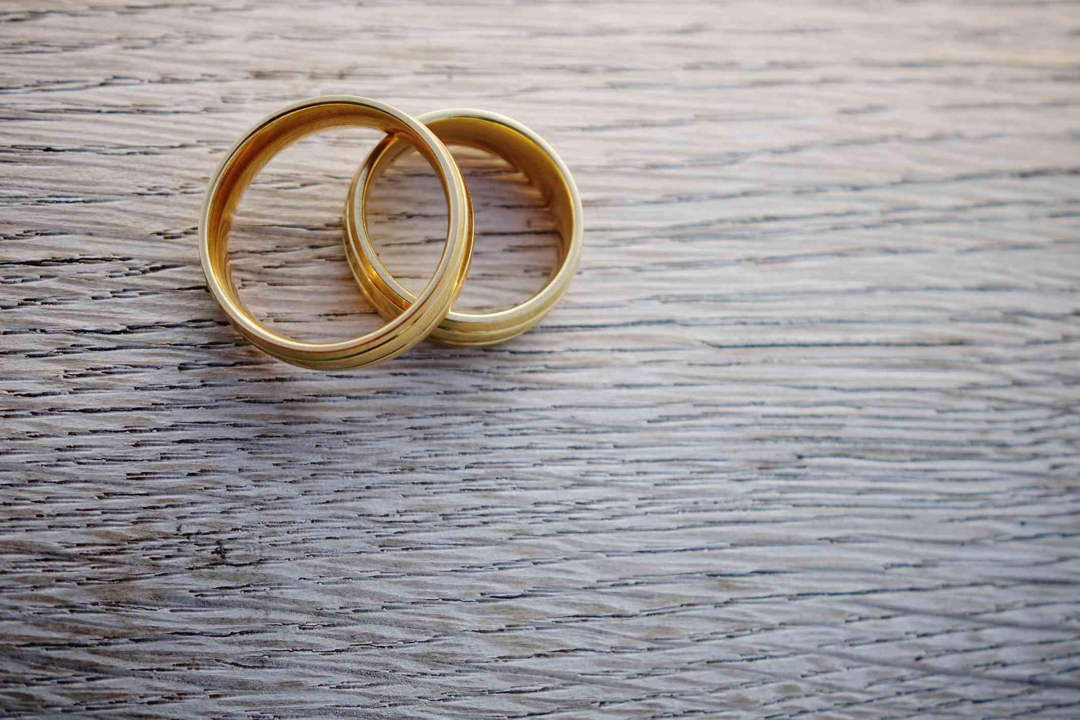 Een paar gouden trouwringen symboliseren het huwelijk.  Leer hier de sociologische definitie.