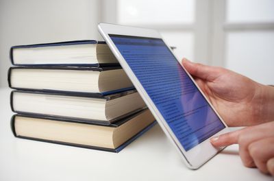 Foto van boeken en een tablet met een ebook